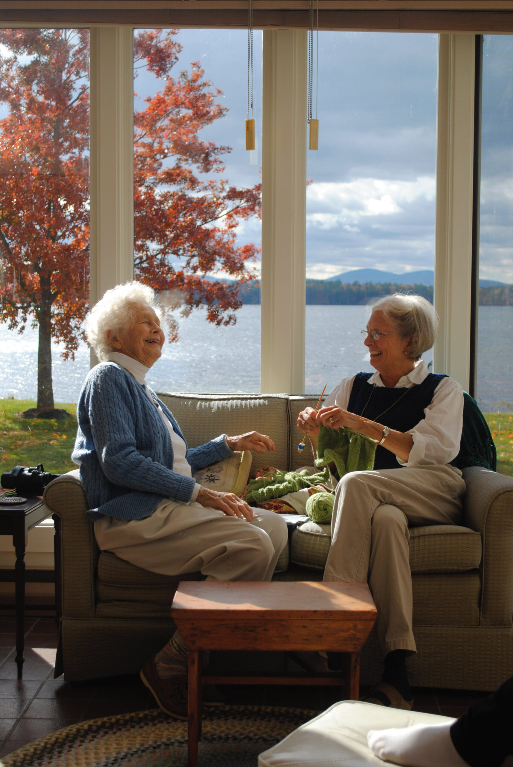 Elderly women knitting and laughing.